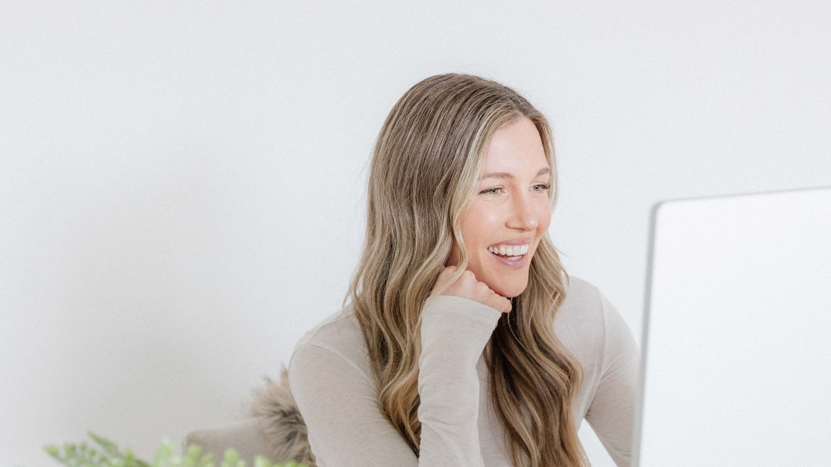A GutPersonal dietitian smiling on a video consultation at her desk